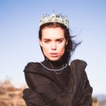 woman in black jacket wearing white flower crown