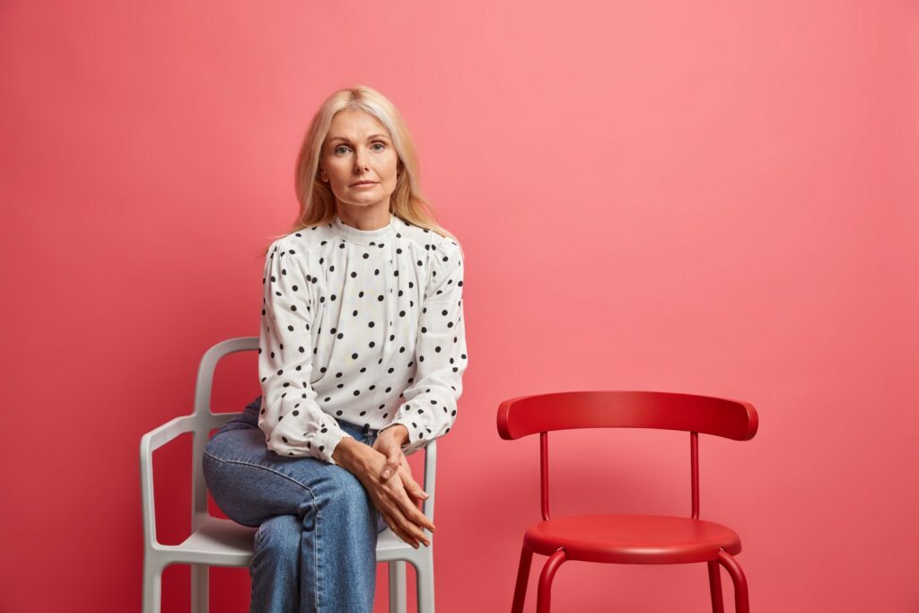 woman looks poses well dressed comfortable chair being alone waits queue isolated vivid pink