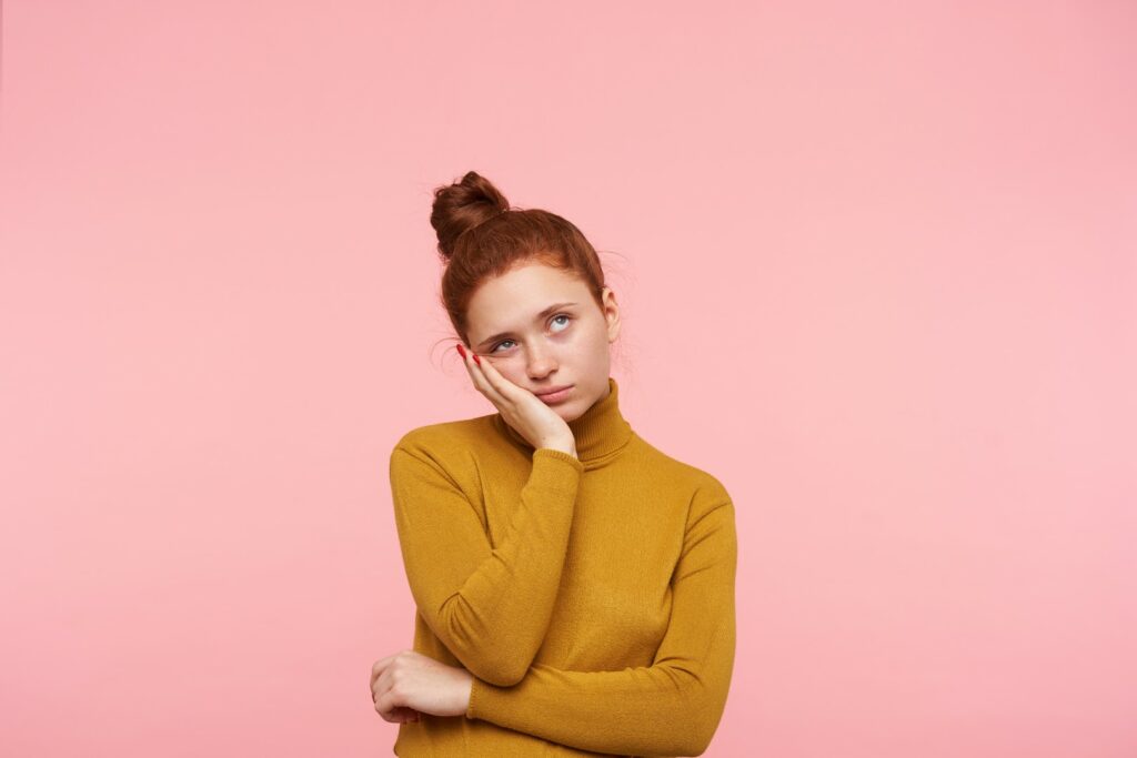 young pretty redhead female with bun hairstyle isolated